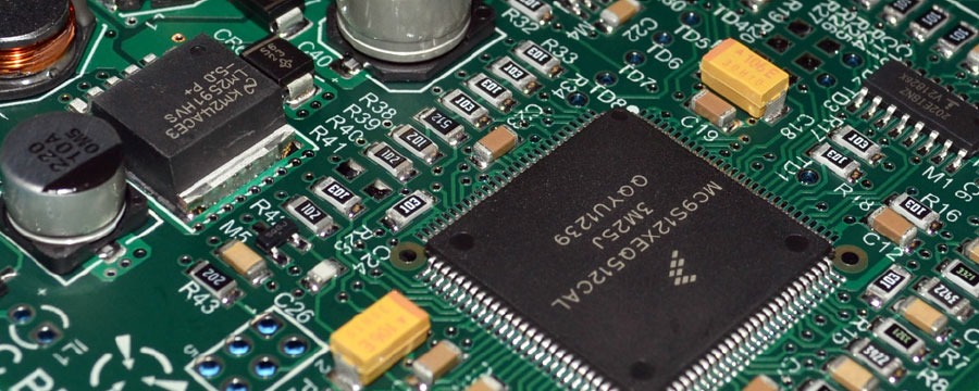 Populated printed circuit board under inspection, with surface mount components visible along the edge