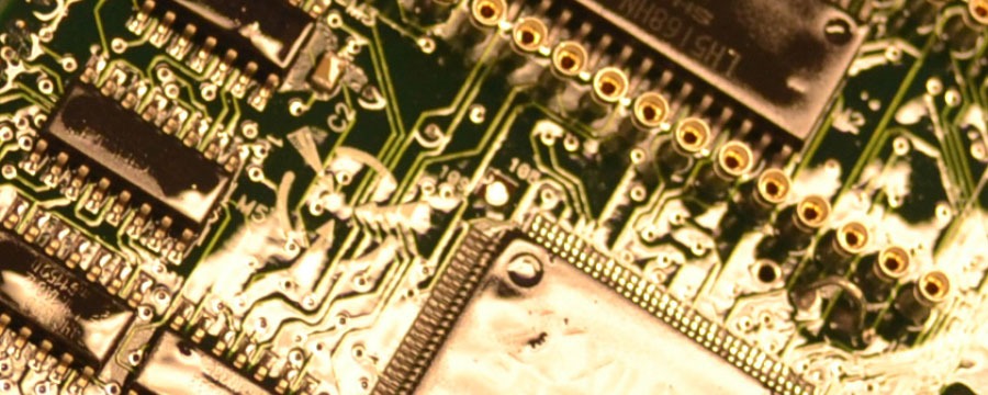 Conformal coated assembly under UV inspection light, coating fluorescing across the components