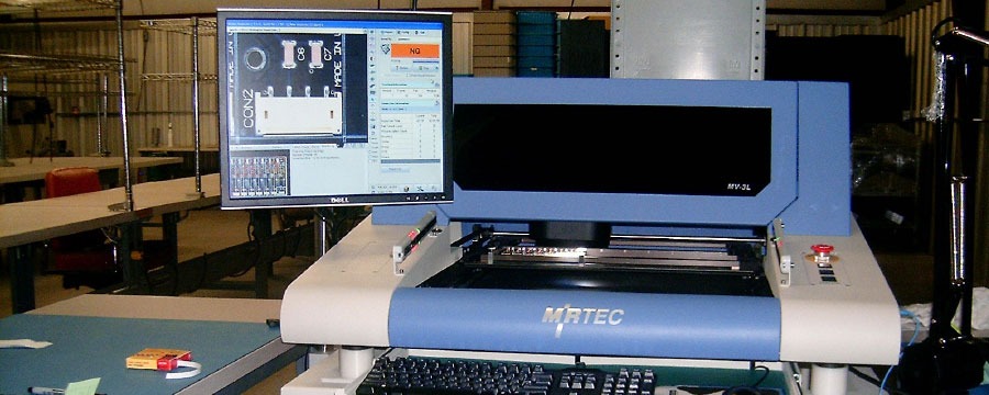 MIRTEC automated optical inspection station scanning a populated circuit board on the Greene, NY floor